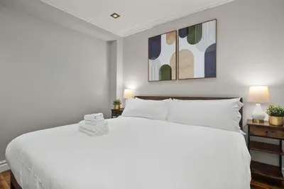a bedroom with a large white bed with two lamps at Sleek Midtown East Stay Near Everything in New York