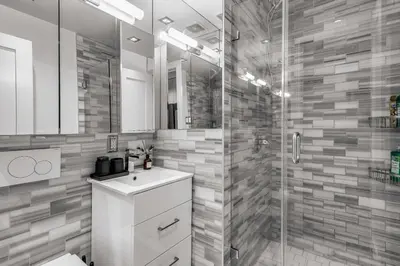 a bathroom with a shower and a sink and a toilet at Sleek Midtown East Stay Near Everything in New York