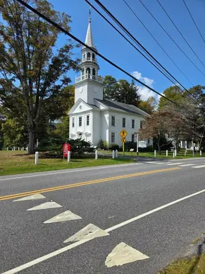 a white church with a steeple on the side of a road at Perch, for work or wandering the Litchfield Hills in Southbury