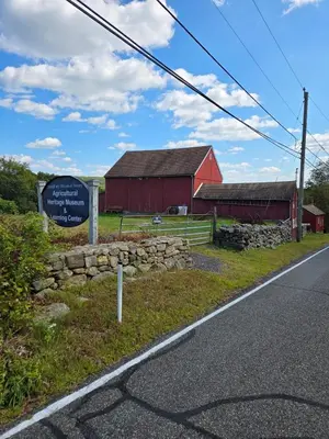a sign next to a red barn and a road at Perch, for work or wandering the Litchfield Hills in Southbury