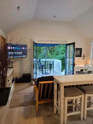 a living room with a table and a balcony at Perch, for work or wandering the Litchfield Hills in Southbury