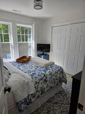 a bedroom with a bed with a blue and white comforter at Perch, for work or wandering the Litchfield Hills in Southbury