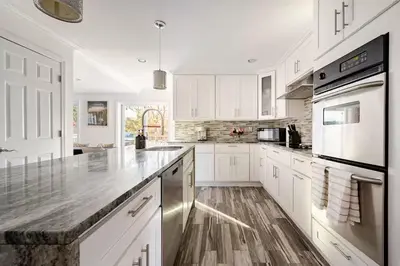 a kitchen with white cabinets and a counter top at Norwalk Retreat in Norwalk