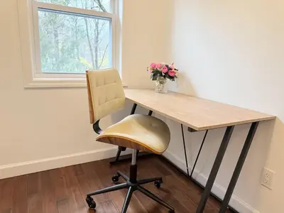 a desk with a chair and a vase of flowers at Norwalk Retreat in Norwalk