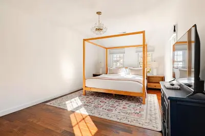 a bedroom with a canopy bed and a television at Norwalk Retreat in Norwalk