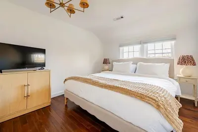 a bedroom with a large bed and a flat screen tv at Norwalk Retreat in Norwalk