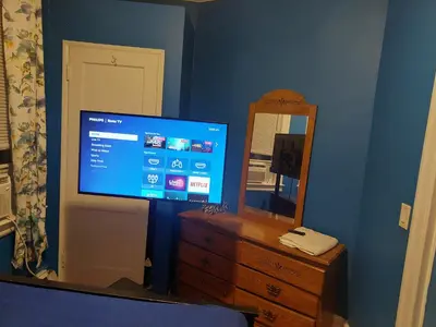 a bedroom with a tv and a dresser with a mirror at Grove#5 in Irvington