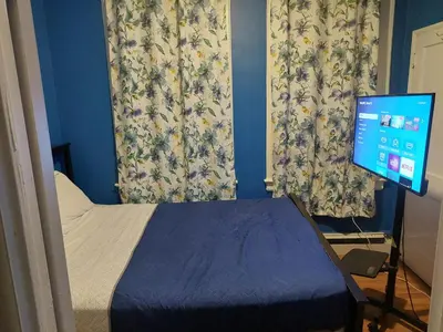 a bedroom with a bed and a computer monitor at Grove#5 in Irvington