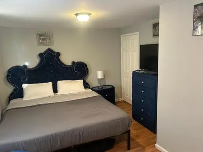 a bedroom with a bed and a dresser with a television at 1052grovest #3 in Irvington