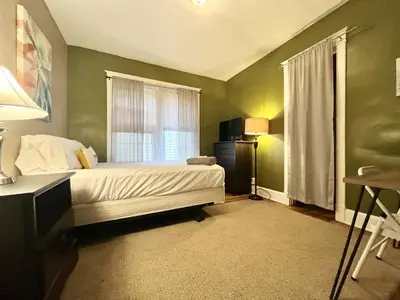 a bedroom with a bed with green walls and a window at Binghamton Hospitals Private Room Shared Spaces Trades Medical Staff Welcom in Binghamton