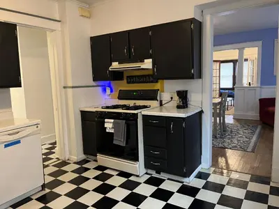 a kitchen with black appliances and a checkered floor at Binghamton Hospitals Private Room Shared Spaces Trades Medical Staff Welcom in Binghamton