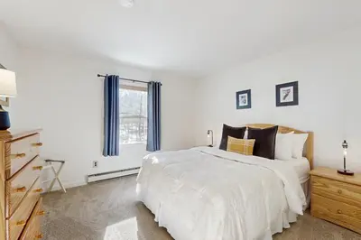 a white bedroom with a large bed and a window at Equipe Sport 2E in Dover