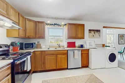 a kitchen with wooden cabinets and a washer and dryer at Equipe Sport 2E in Dover
