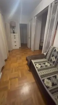 a living room with a couch and a wooden floor at Holiday Glow Apartments in Rego Park
