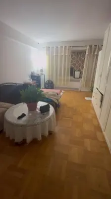 a living room with a couch and a table at Holiday Glow Apartments in Rego Park