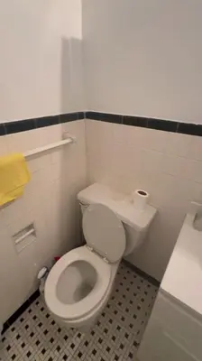 a bathroom with a white toilet and a sink at Holiday Glow Apartments in Rego Park