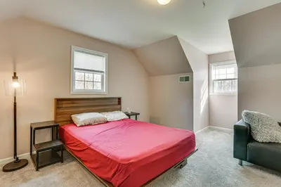 a bedroom with a red bed and a chair at Hike, Ski and Game Spacious Poconos Home with Yard in Tobyhanna