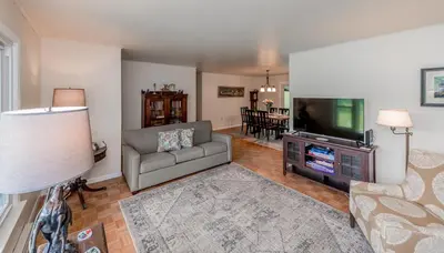 a living room with a couch and a flat screen tv at Catskill gem! Four bedroom on 20 quiet acres in Barryville