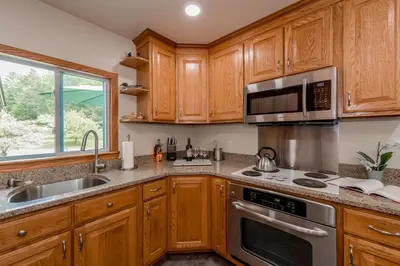 a kitchen with wooden cabinets and a sink and a microwave at Catskill gem! Four bedroom on 20 quiet acres in Barryville