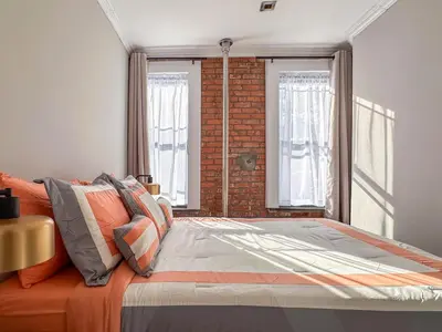a bedroom with a bed and a brick wall at Suite 45 - East Harlem, Manhattan by Monthier in New York