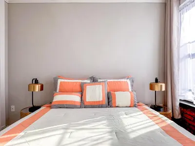 a bedroom with a bed with orange and white pillows at Suite 45 - East Harlem, Manhattan by Monthier in New York