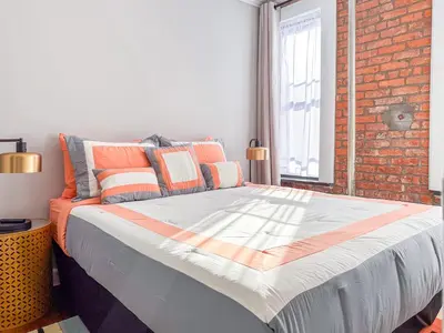 a large bed in a room with a brick wall at Suite 45 - East Harlem, Manhattan by Monthier in New York