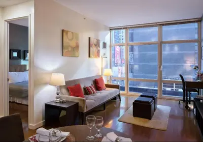 a living room with a couch and a large window at 1600 Broadway in New York