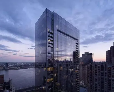 a tall glass building in front of a city at 685 First Ave in New York