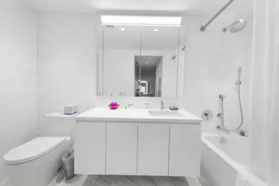 a white bathroom with a sink and a toilet at 685 First Ave in New York