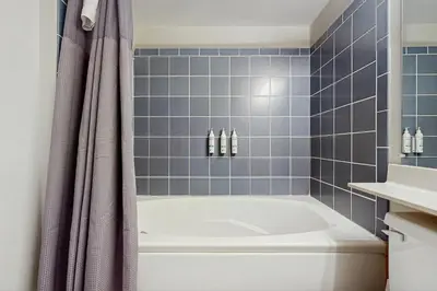 a blue tiled bathroom with a tub and a sink at The Seasons P21 in West Dover