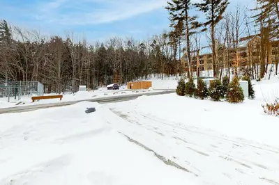 a road covered in snow with trees and a building at The Seasons P21 in West Dover