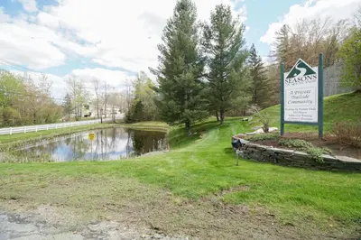a sign in the grass next to a pond at The Seasons P21 in West Dover