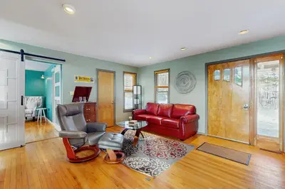 a living room with a red couch and chairs at Deer Hill Retreat in Whitingham