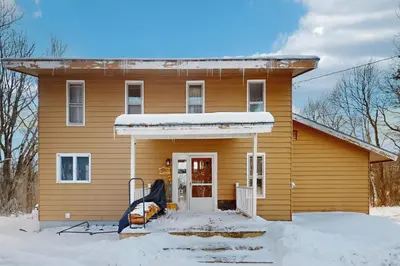 a house with snow on the front of it at Deer Hill Retreat in Whitingham