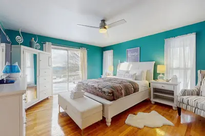 a bedroom with blue walls and a bed and a couch at Deer Hill Retreat in Whitingham