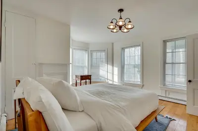 a bedroom with a bed with white sheets and a chandelier at 7 Mi to The Walkway Hudson Valley Adventure Base in Highland
