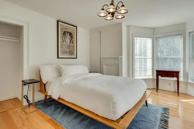 a bedroom with a large white bed with a chandelier at 7 Mi to The Walkway Hudson Valley Adventure Base in Highland
