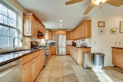 a large kitchen with wooden cabinets and stainless steel appliances at 7 Mi to The Walkway Hudson Valley Adventure Base in Highland