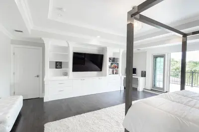 a white bedroom with a bed and a tv at Luxury 4BR Magical Oasis Villa Mansion with Indoor Basketball Court and Gym in Melville