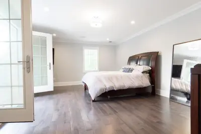 a bedroom with a bed and a large mirror at Luxury 4BR Magical Oasis Villa Mansion with Indoor Basketball Court and Gym in Melville