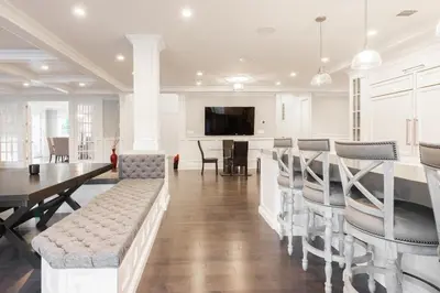 a living room with a table and chairs and a kitchen at Luxury 4BR Magical Oasis Villa Mansion with Indoor Basketball Court and Gym in Melville