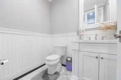 a white bathroom with a toilet and a sink at Luxury 4BR Magical Oasis Villa Mansion with Indoor Basketball Court and Gym in Melville