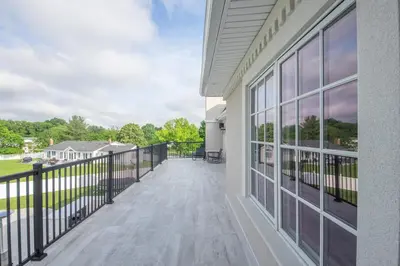 a balcony of a house with a view of a yard at Luxury 4BR Magical Oasis Villa Mansion with Indoor Basketball Court and Gym in Melville