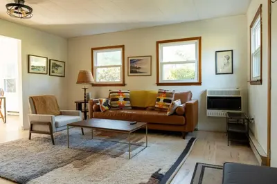 a living room with a couch and a table at Riverfront Poconos Cabin with Hot Tub on 4 Acres Near Delaware River (Sleeps 6) in Lackawaxen