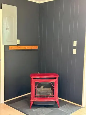 a red fireplace in a room with gray walls at Riverfront Poconos Cabin with Hot Tub on 4 Acres Near Delaware River (Sleeps 6) in Lackawaxen