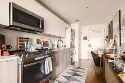 a kitchen with a stove and a microwave at Beautiful Modern Studio in Luxury Building in Brooklyn