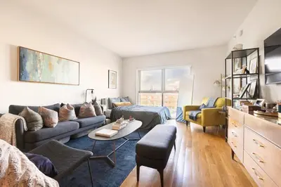 a living room with a couch and a table at Beautiful Modern Studio in Luxury Building in Brooklyn