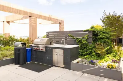 a outdoor kitchen with a sink and a grill at Beautiful Modern Studio in Luxury Building in Brooklyn