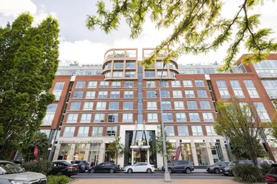 a large building with cars parked in a parking lot at Beautiful Modern Studio in Luxury Building in Brooklyn
