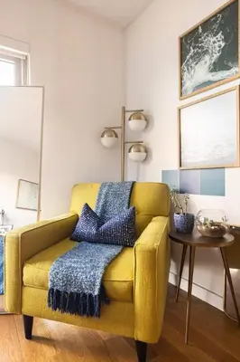 a yellow chair in a living room with a table at Beautiful Modern Studio in Luxury Building in Brooklyn